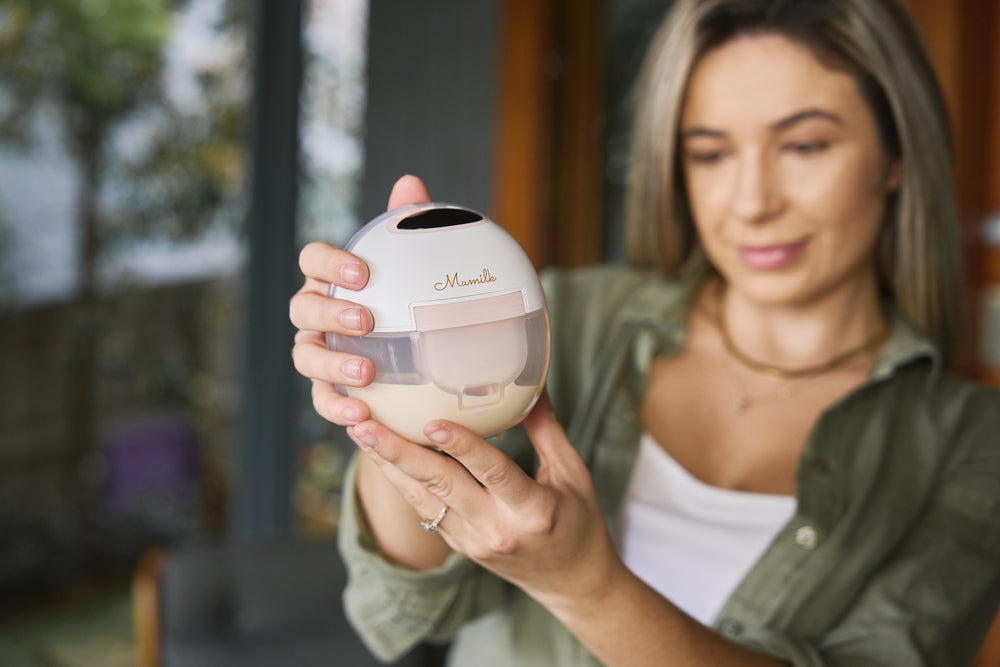 Woman holding a portable wearable breast pump